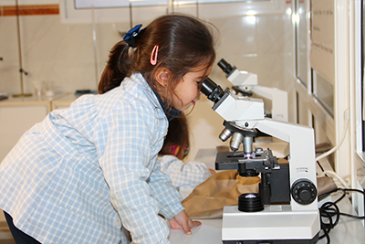 Alumno mirando microscopio